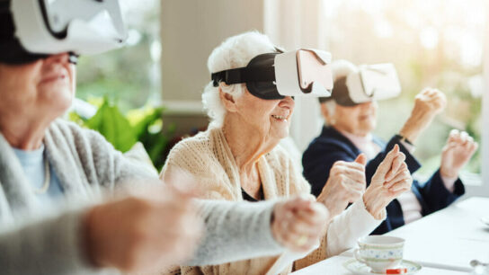 Close-up-of-senior-women-happy-using-virtual-reality-headset-at-a-retirement-home.