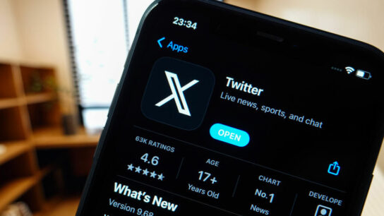 TheTwitter "X" app's new logo is displayed on the screen of a smartphone.